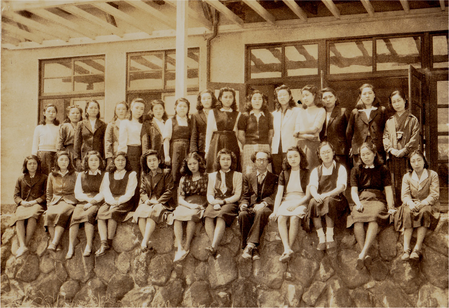 先生と学生たち。旧本館裏の石垣の上で。大分県に女子専門学校が誕生したことは画期的なことだった。（昭和23年頃）